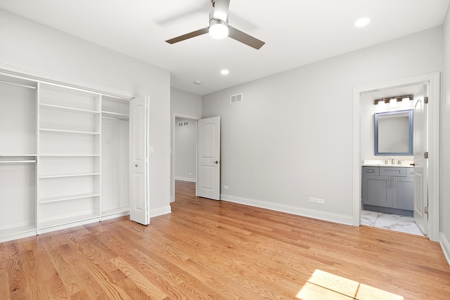 unfurnished bedroom with a sink, a closet, light wood finished floors, baseboards, and recessed lighting