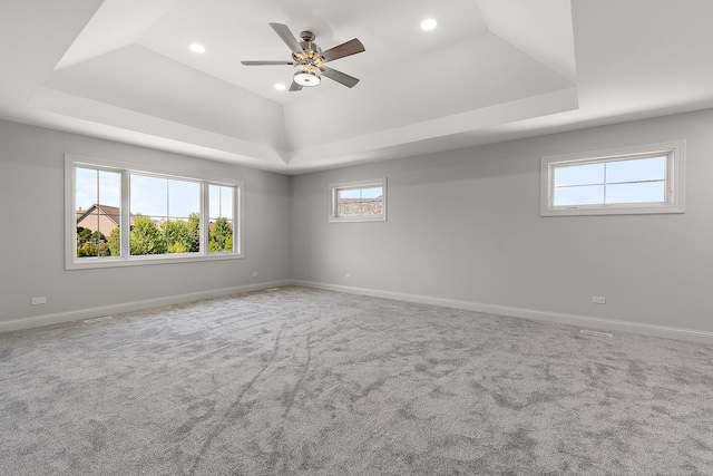carpeted spare room with a raised ceiling, baseboards, ceiling fan, and recessed lighting
