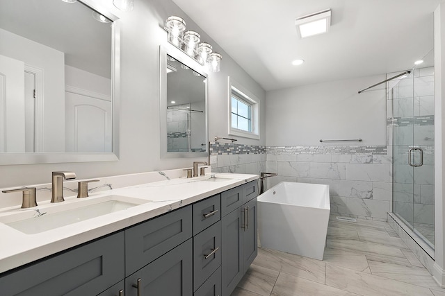 full bath featuring marble look tiles, a stall shower, tile walls, a soaking tub, and double vanity