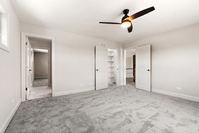 unfurnished bedroom featuring carpet floors, baseboards, and ceiling fan