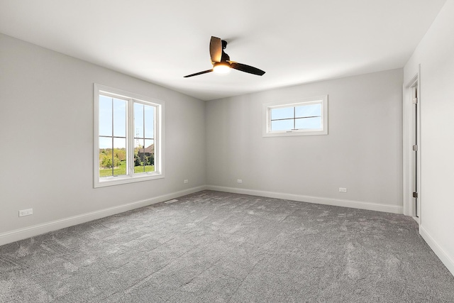 carpeted empty room featuring a ceiling fan and baseboards