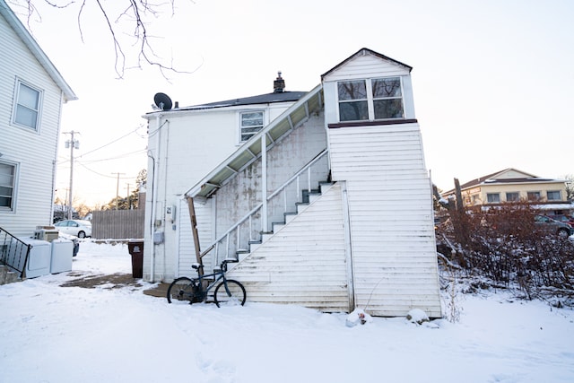 view of snow covered rear of property