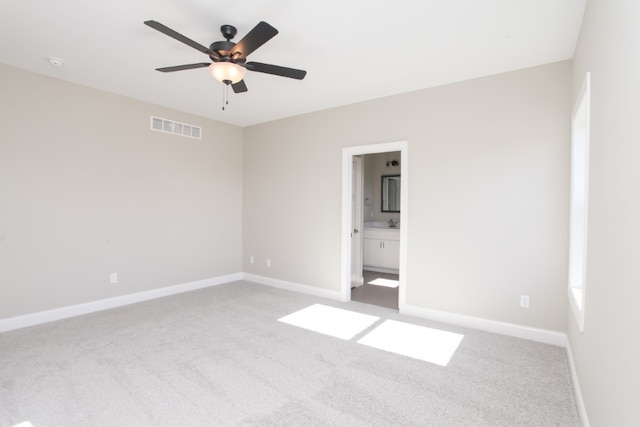 spare room featuring ceiling fan and light carpet