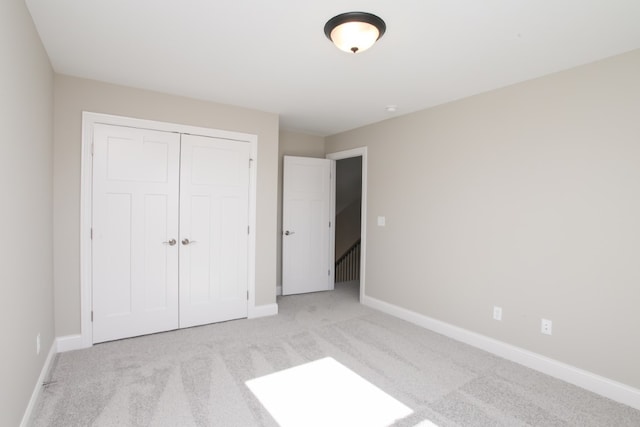 unfurnished bedroom featuring a closet and light carpet