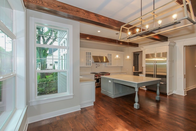 kitchen with hanging light fixtures, white cabinetry, high end appliances, and dark wood-type flooring