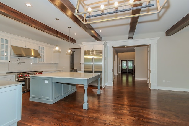 kitchen with high end appliances, dark wood-type flooring, a breakfast bar area, white cabinetry, and hanging light fixtures