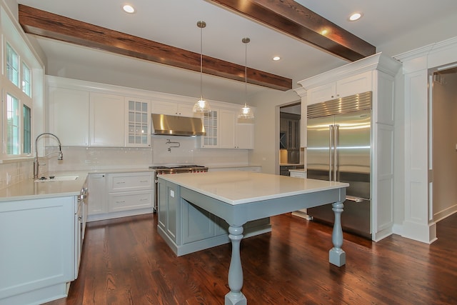 kitchen featuring tasteful backsplash, white cabinetry, a center island, and stainless steel built in refrigerator