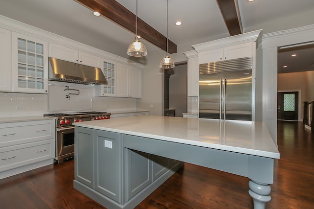 kitchen featuring premium appliances, dark hardwood / wood-style floors, a center island, and white cabinetry