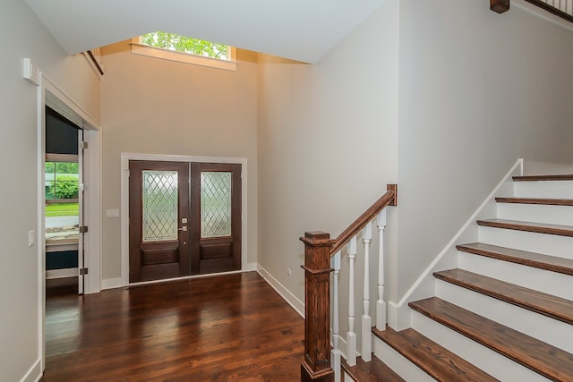 entryway with dark hardwood / wood-style floors, french doors, and a towering ceiling