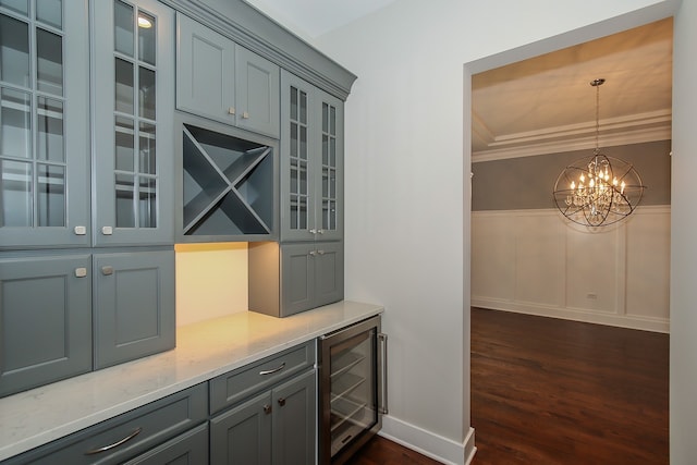 bar with light stone countertops, dark wood-type flooring, wine cooler, a chandelier, and pendant lighting