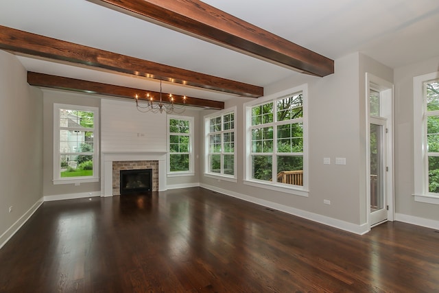 unfurnished living room featuring dark hardwood / wood-style flooring, plenty of natural light, and a chandelier