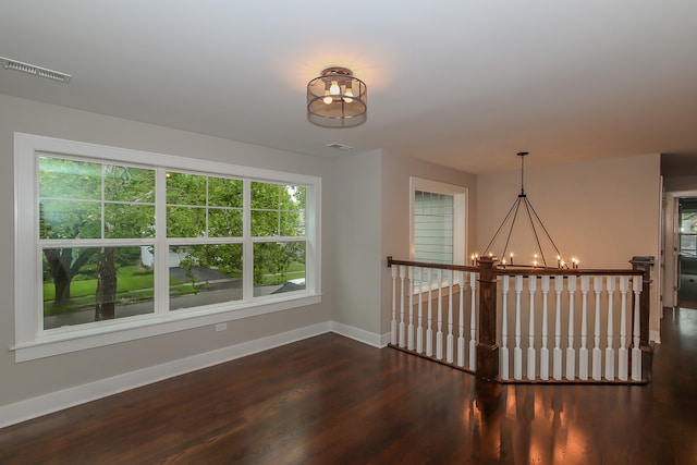 unfurnished room with dark hardwood / wood-style flooring and a chandelier