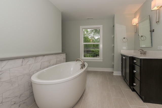 bathroom featuring tile walls, tile flooring, vanity, and a washtub