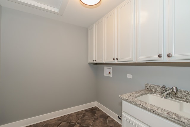 laundry area featuring hookup for a washing machine, sink, cabinets, and dark tile flooring