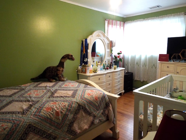 bedroom with ornamental molding and wood-type flooring