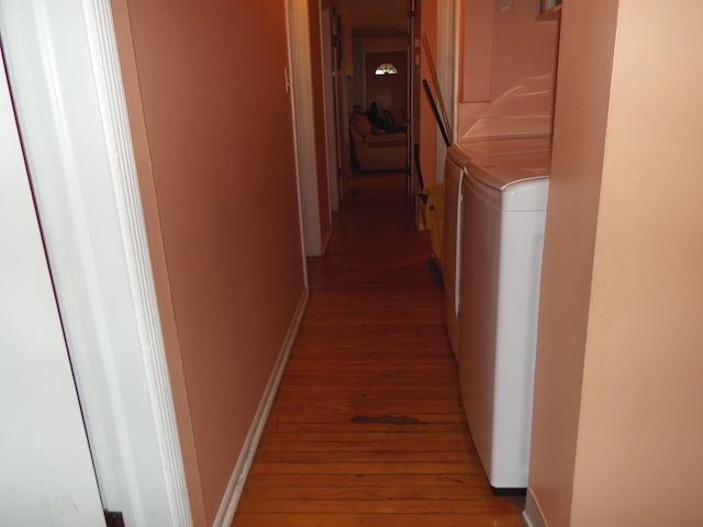 hall with independent washer and dryer and light hardwood / wood-style flooring