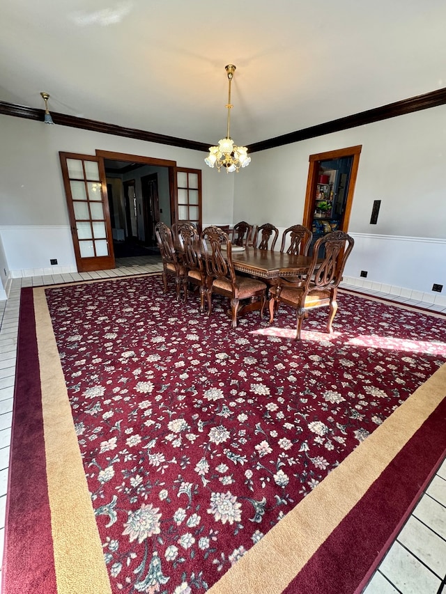 carpeted dining area with ornamental molding and an inviting chandelier