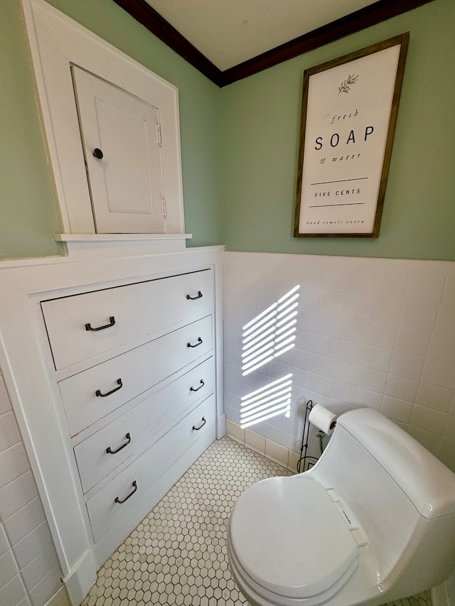 interior space featuring tile walls, ornamental molding, toilet, and tile patterned flooring