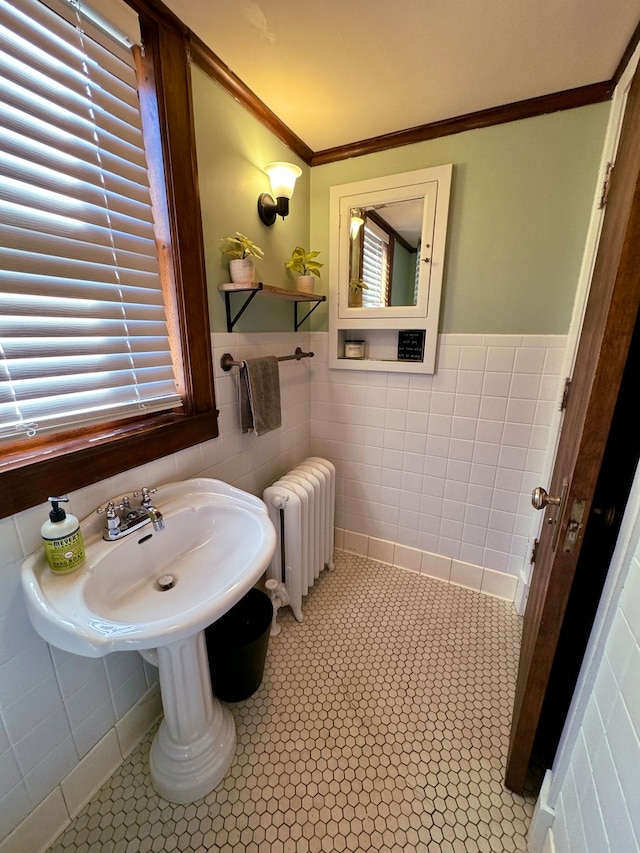 bathroom with ornamental molding, radiator heating unit, tile walls, and tile patterned flooring