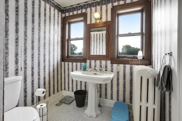 bathroom featuring toilet, radiator heating unit, and tile patterned flooring