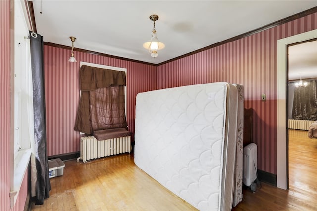 bedroom featuring radiator, ornamental molding, and hardwood / wood-style floors