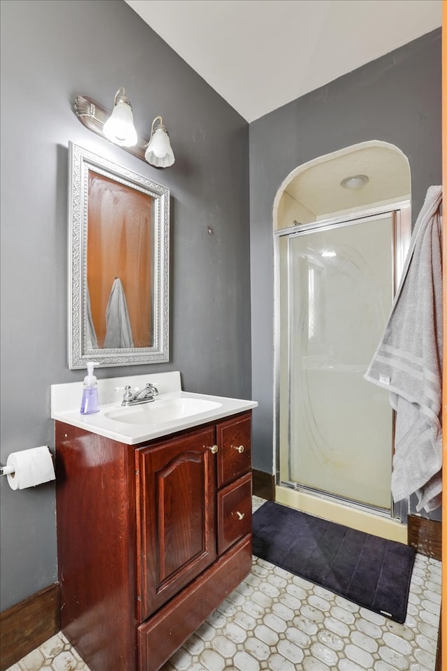 bathroom featuring vanity and a shower with shower door