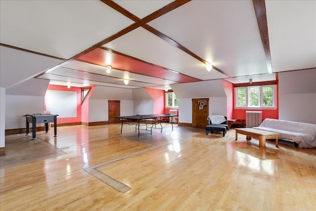 game room featuring hardwood / wood-style flooring, beamed ceiling, radiator, and plenty of natural light