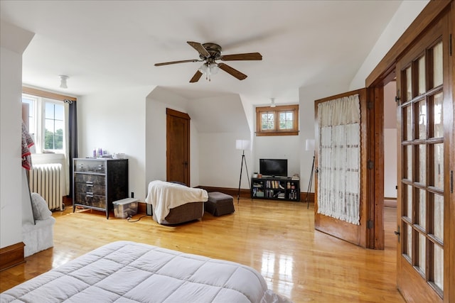 bedroom featuring radiator, light hardwood / wood-style floors, and ceiling fan