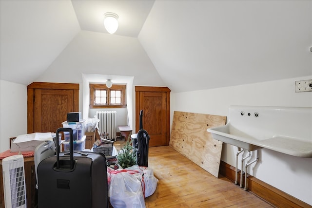 bonus room featuring light hardwood / wood-style floors, radiator heating unit, and vaulted ceiling