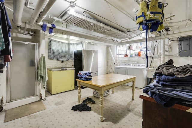 basement featuring white fridge, electric panel, washing machine and clothes dryer, and stainless steel refrigerator