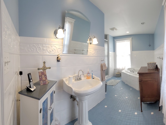 bathroom with tile flooring, tile walls, backsplash, sink, and a bath