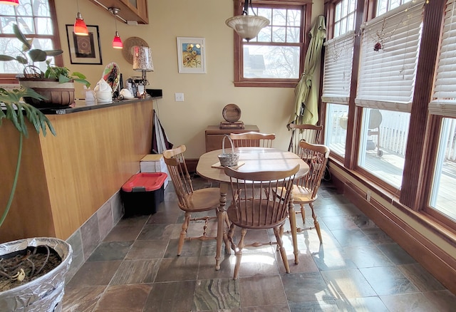 dining space featuring dark tile flooring and a healthy amount of sunlight