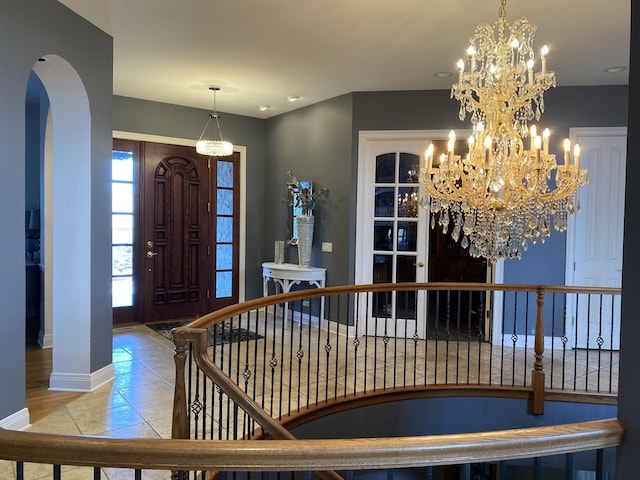 tiled foyer entrance featuring an inviting chandelier