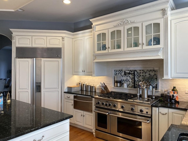 kitchen featuring white cabinetry, double oven range, paneled fridge, and tasteful backsplash