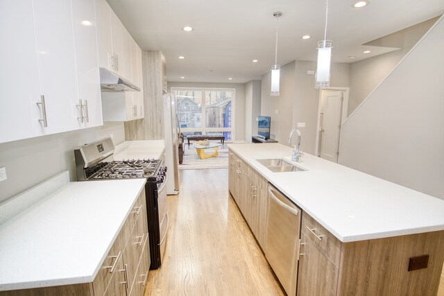 2520 S Stark St, Chicago, IL 60608 - kitchen with pendant lighting, appliances with stainless steel finishes, white cabinetry, a kitchen island with sink, and sink