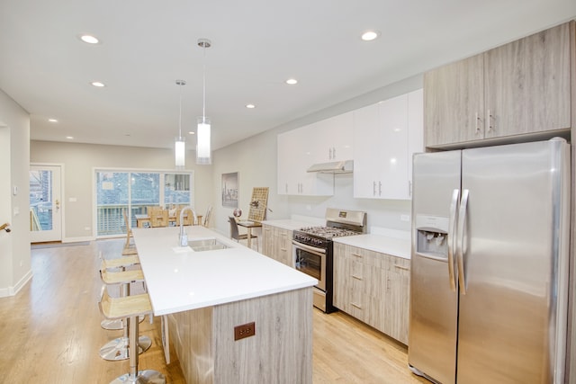 2520 S Stark St, Chicago, IL 60608 - kitchen with a kitchen breakfast bar, appliances with stainless steel finishes, light hardwood / wood-style floors, sink, and pendant lighting