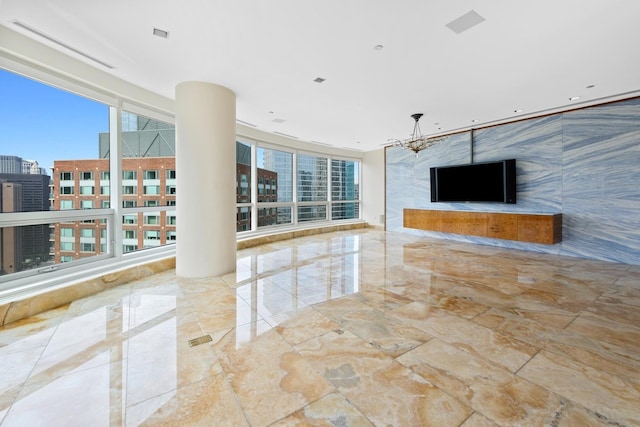 unfurnished living room with a healthy amount of sunlight and an inviting chandelier