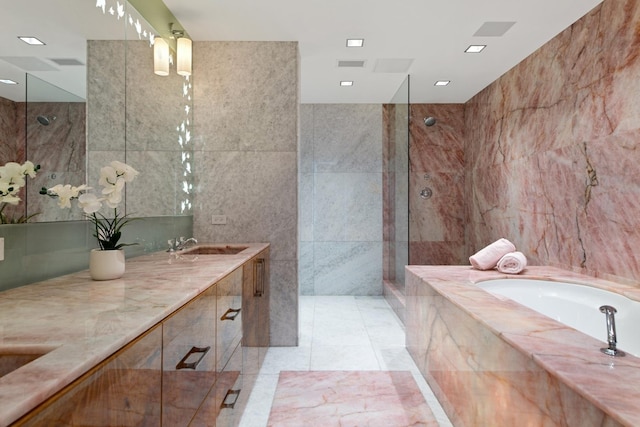 bathroom featuring tile patterned flooring, vanity, separate shower and tub, and tile walls