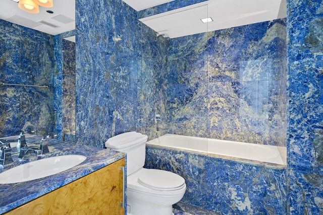 bathroom with a relaxing tiled tub, vanity, and toilet