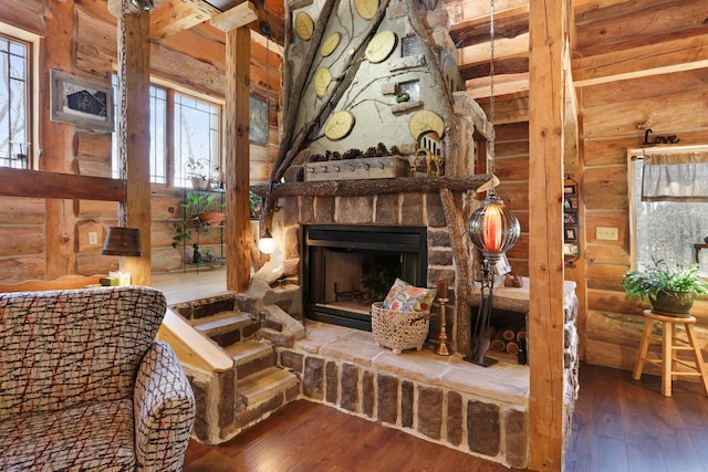 living room with dark hardwood / wood-style flooring, a healthy amount of sunlight, and a stone fireplace