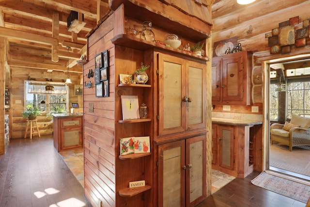 interior space with log walls, a healthy amount of sunlight, and light wood-type flooring