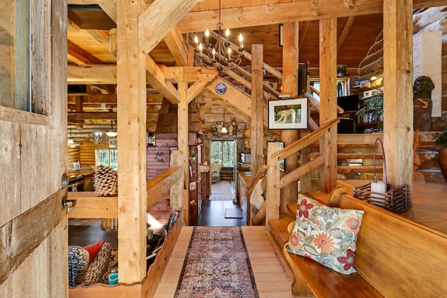 misc room featuring log walls, hardwood / wood-style floors, a notable chandelier, and lofted ceiling with beams