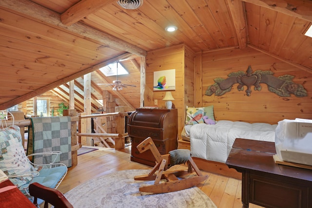 bedroom with vaulted ceiling with skylight, wood walls, wood ceiling, and light wood-type flooring