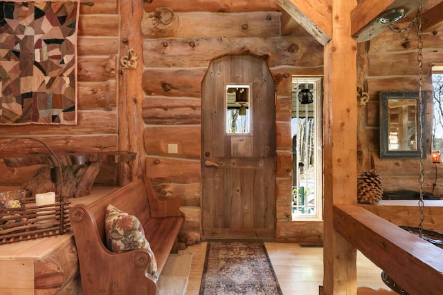 entrance foyer featuring light wood-type flooring and rustic walls