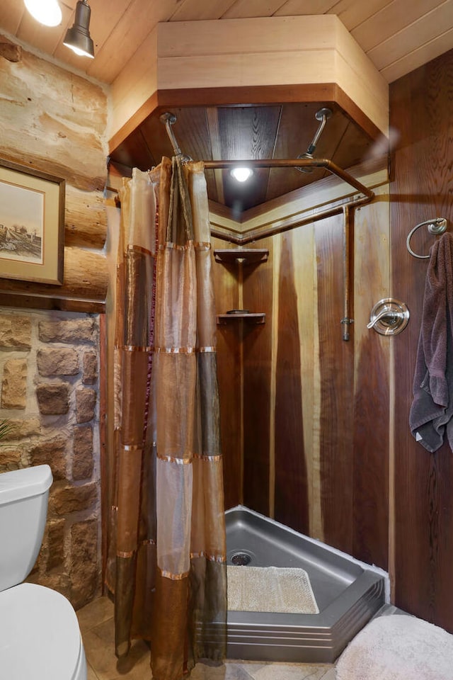 bathroom with wooden ceiling, toilet, and walk in shower