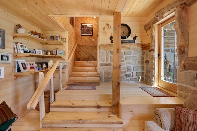 stairway featuring wood ceiling and light hardwood / wood-style flooring