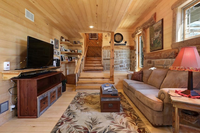 living room with wooden walls, wooden ceiling, and light wood-type flooring