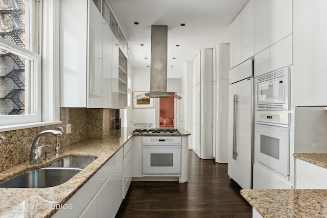 kitchen featuring dark wood-type flooring, tasteful backsplash, white appliances, island exhaust hood, and white cabinets