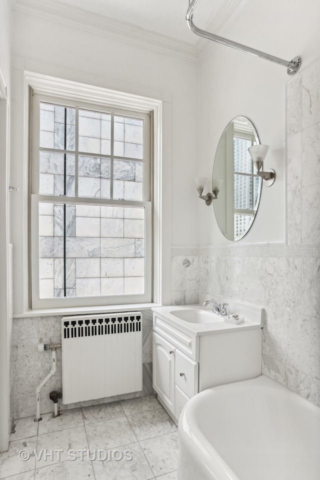 bathroom featuring radiator heating unit, vanity, and a wealth of natural light