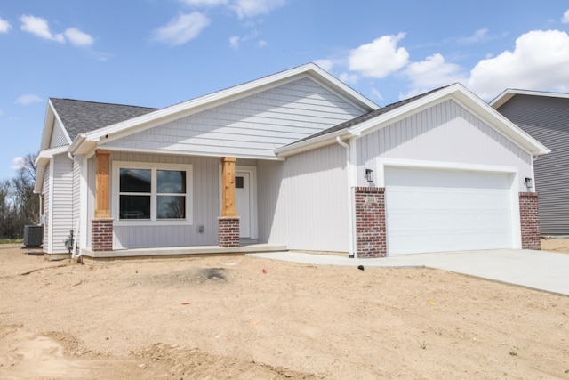 view of front of home with a porch, central AC, and a garage